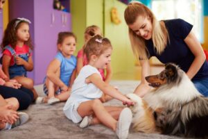 Animal assisted therapy being used in a classroom of children.