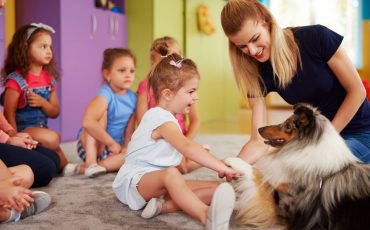 Animal assisted therapy being used in a classroom of children.