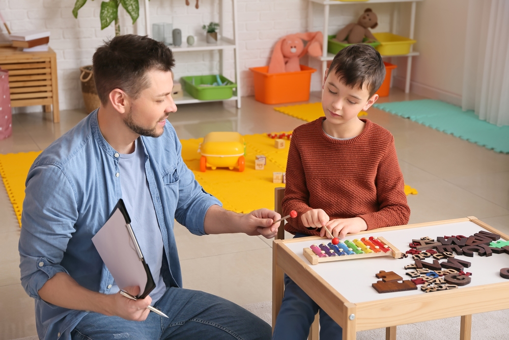 Therapist doing sensory therapy for student with autism in the classroom