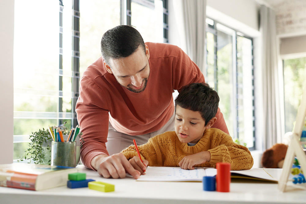 male teacher helping student with writing